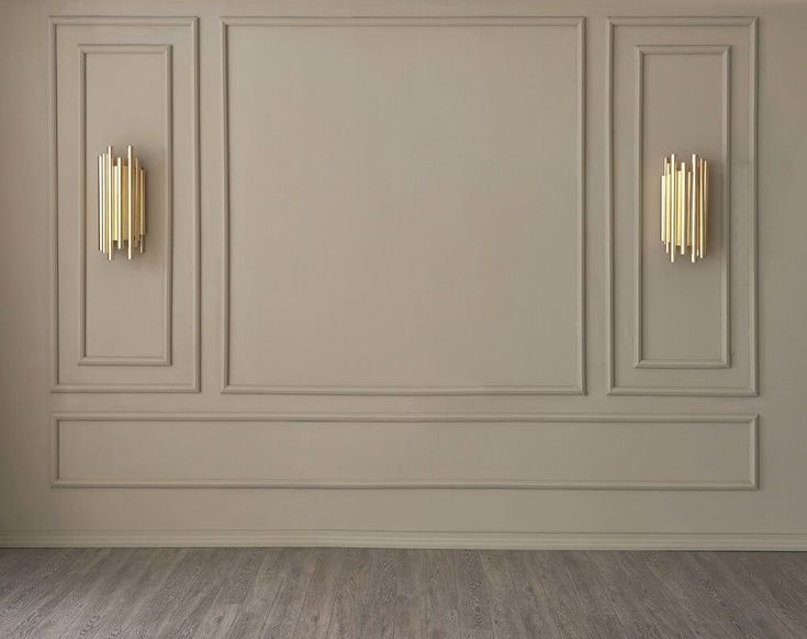 an empty room with white walls and wood flooring, two gold handles on the wall