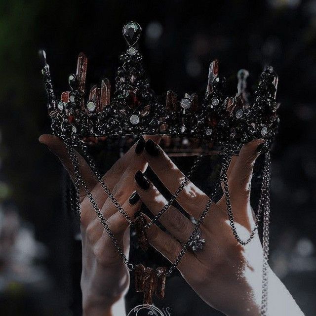 a woman holding up a crown in her hands