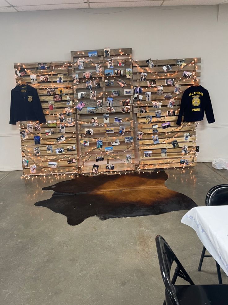 a cow skin rug in front of a wooden wall with pictures and lights on it