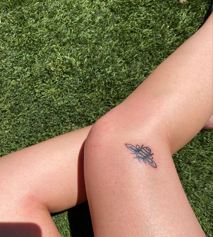 a woman's legs with a small tattoo on them