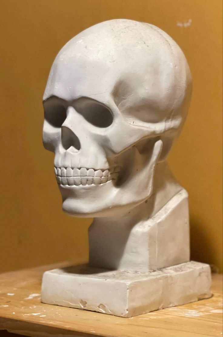 a white skull statue sitting on top of a wooden table