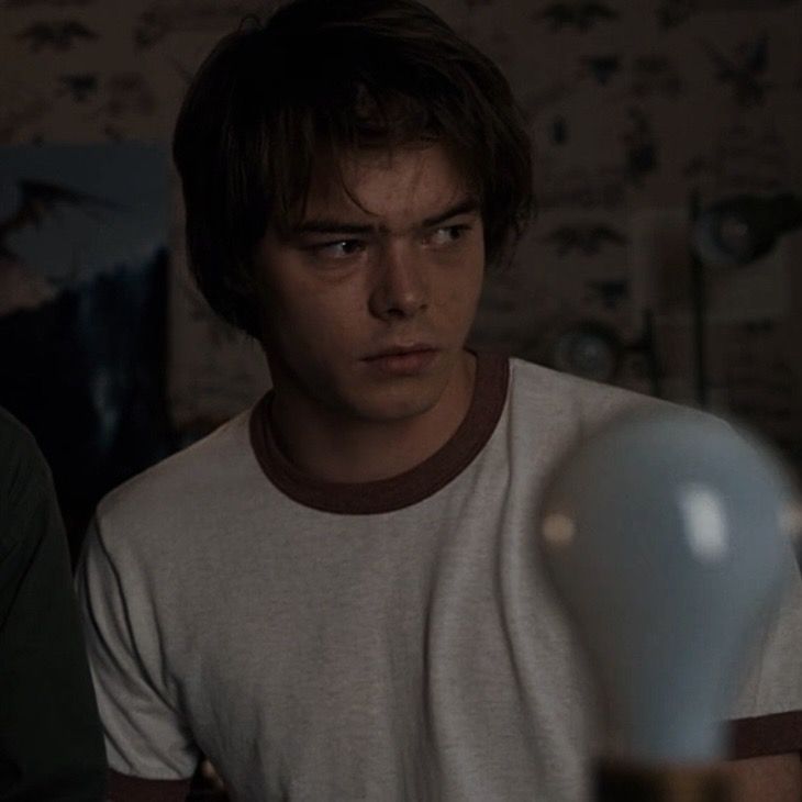 two young men sitting next to each other in front of a table with a light bulb on it