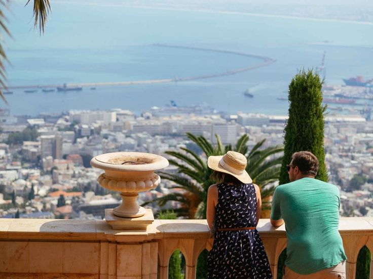 two people are sitting on a ledge overlooking the city