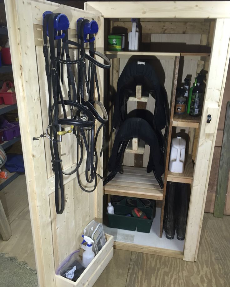 the inside of a horse stable with several different stalls and equipment in storage boxes on the floor