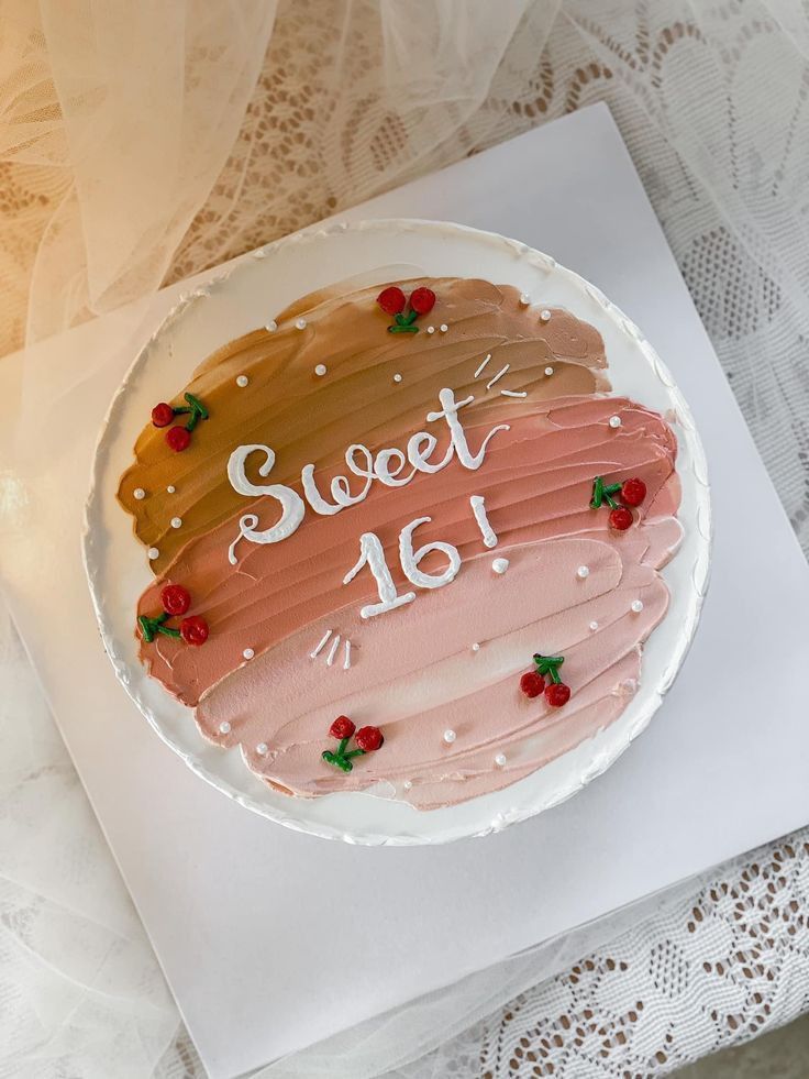 a cake with frosting that says sweet 16 on it sitting on a piece of paper