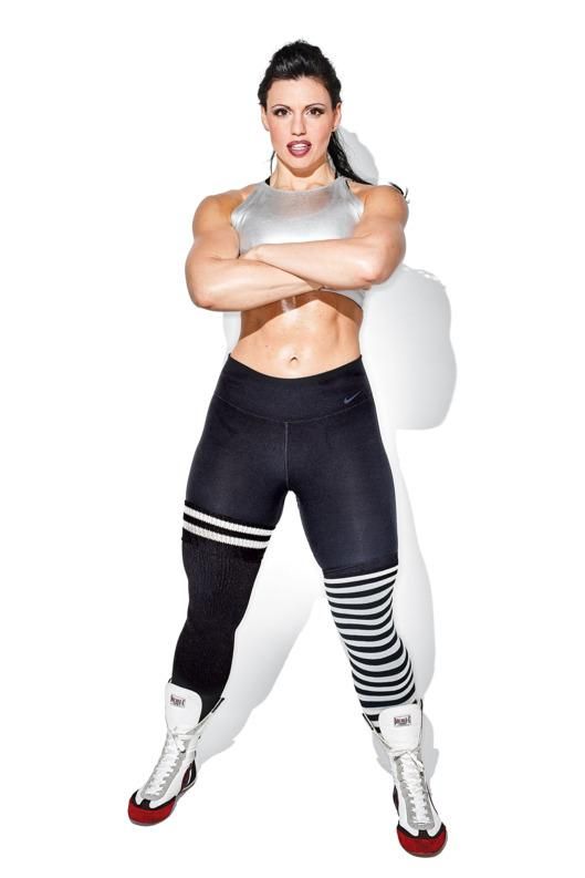 a woman posing with her arms crossed wearing leggings and an athletic bra top