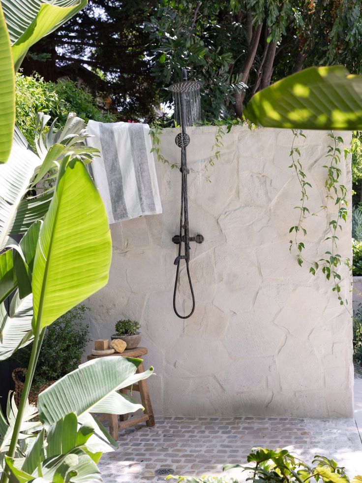 an outdoor shower in the middle of a garden