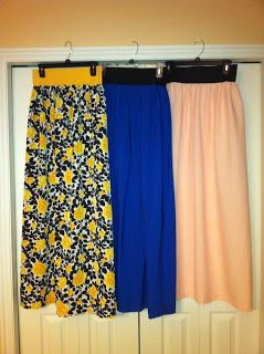 three different colored skirts hanging on a door