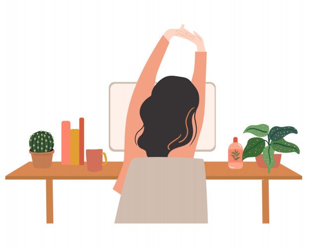 a woman sitting at a desk with her arms up in the air and plants behind her