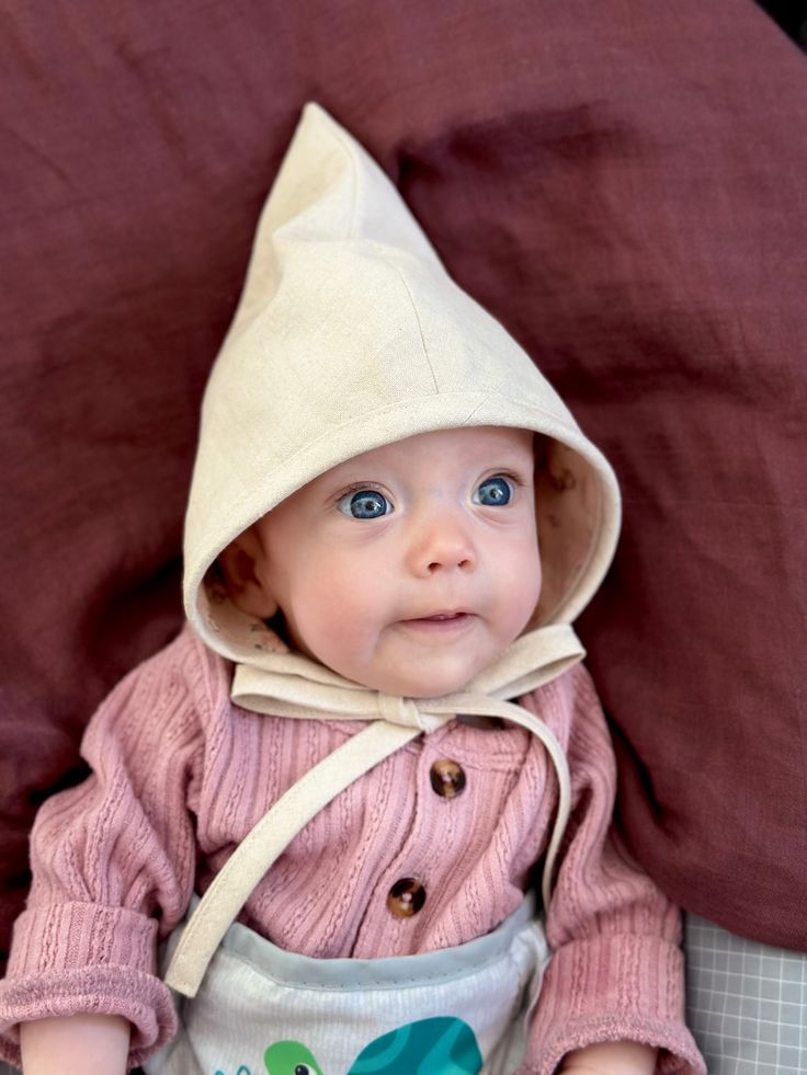 Keep your little one stylish and protected from the sun with this adorable pixie bonnet/ gnome hat! Handcrafted with care and attention to detail, this whimsical hat features a pointed pixie design that adds a touch of charm to any outfit. This also makes a fun and easy part of a gnome or elf costume. Available in sizes 0-3 months, 3-6mo, 6-12mo, 12-18mo, and 18-24mo Prints- 100% cotton Solids- Natural & Red- 55% linen/45% cotton, Green- 100% linen Baby Garden Gnome Costume, Newborn Fairy Costume, Baby Gnome Costume, Whimsical Handmade Bonnet, One Size Fits Most, Pixie Design, Handmade Adjustable Green Bonnet, Gnome Costume, Elf Gnome, Pixie Bonnet