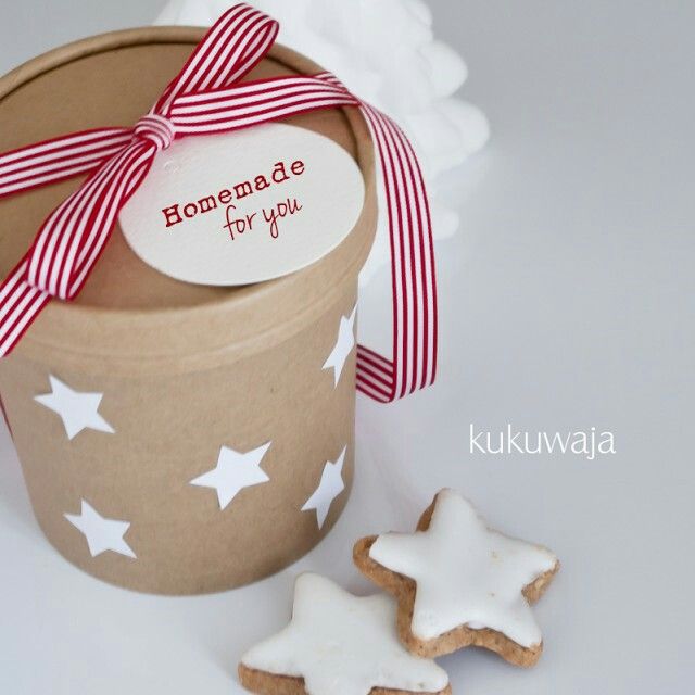 a cookie in a box with a ribbon tied around it and some cookies on the table