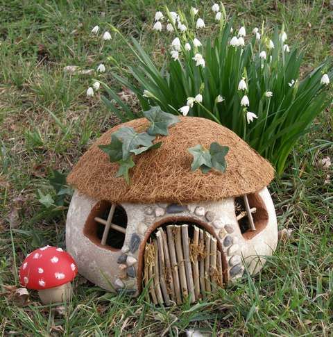 a mushroom shaped house sitting in the grass