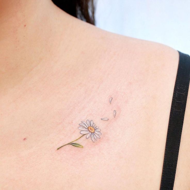 a woman with a tattoo on her back has a flower in the middle of her chest