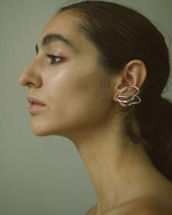 a woman wearing large silver hoop earrings