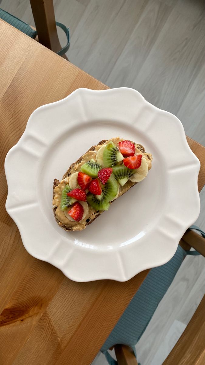 a white plate topped with fruit on top of a wooden table