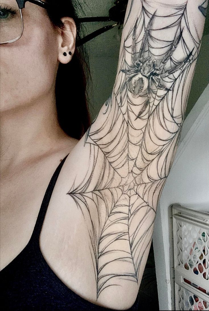 a woman with a spider web tattoo on her arm