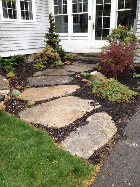 a stone walkway in front of a house