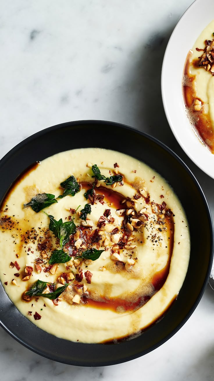 two bowls filled with food sitting on top of a white marble counter next to each other