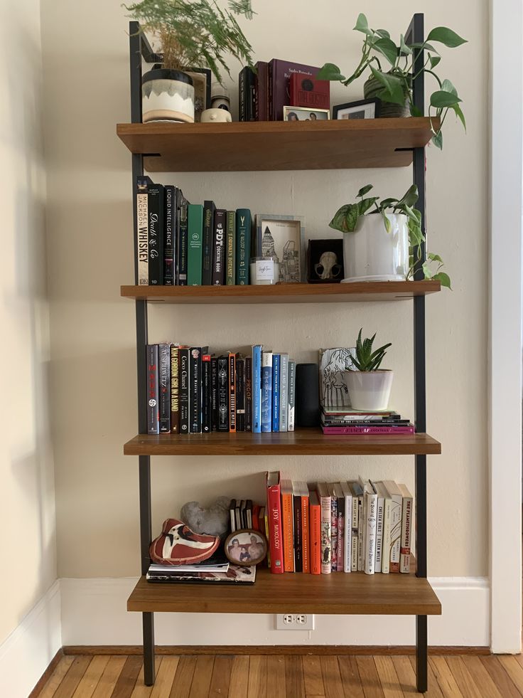 a bookshelf filled with lots of books next to a plant