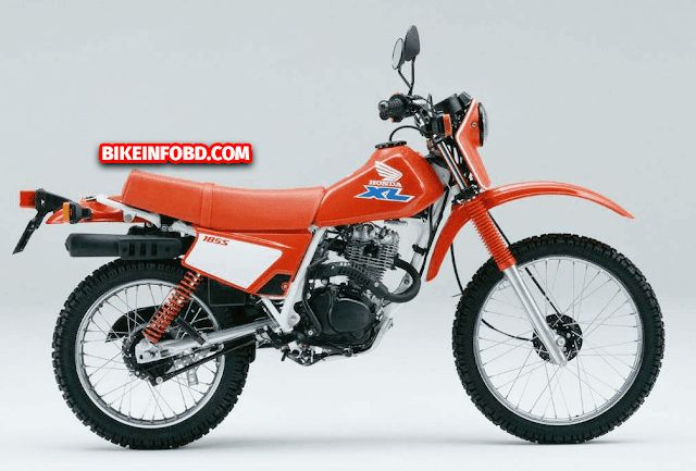 an orange dirt bike parked on top of a white floor