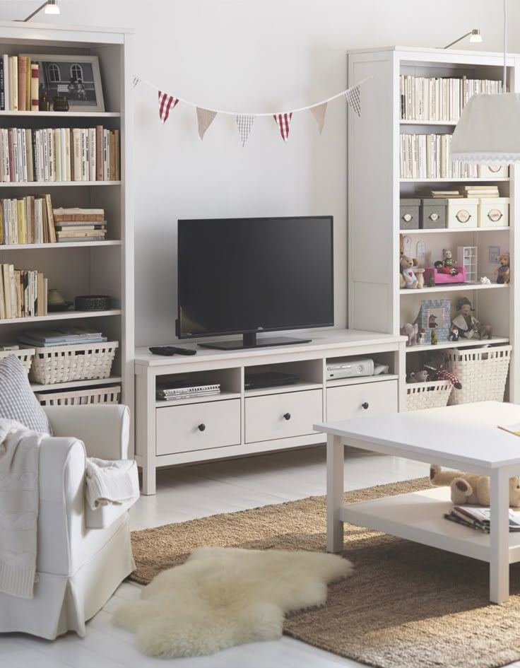 a living room filled with furniture and a flat screen tv on top of a book shelf