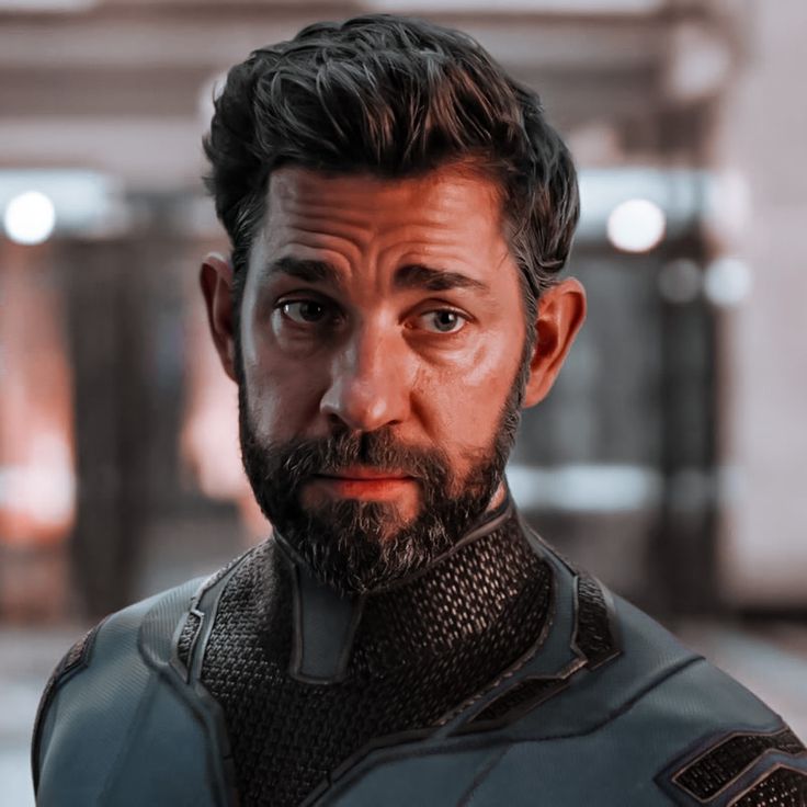 a close up of a person in a suit and beard with a serious look on his face