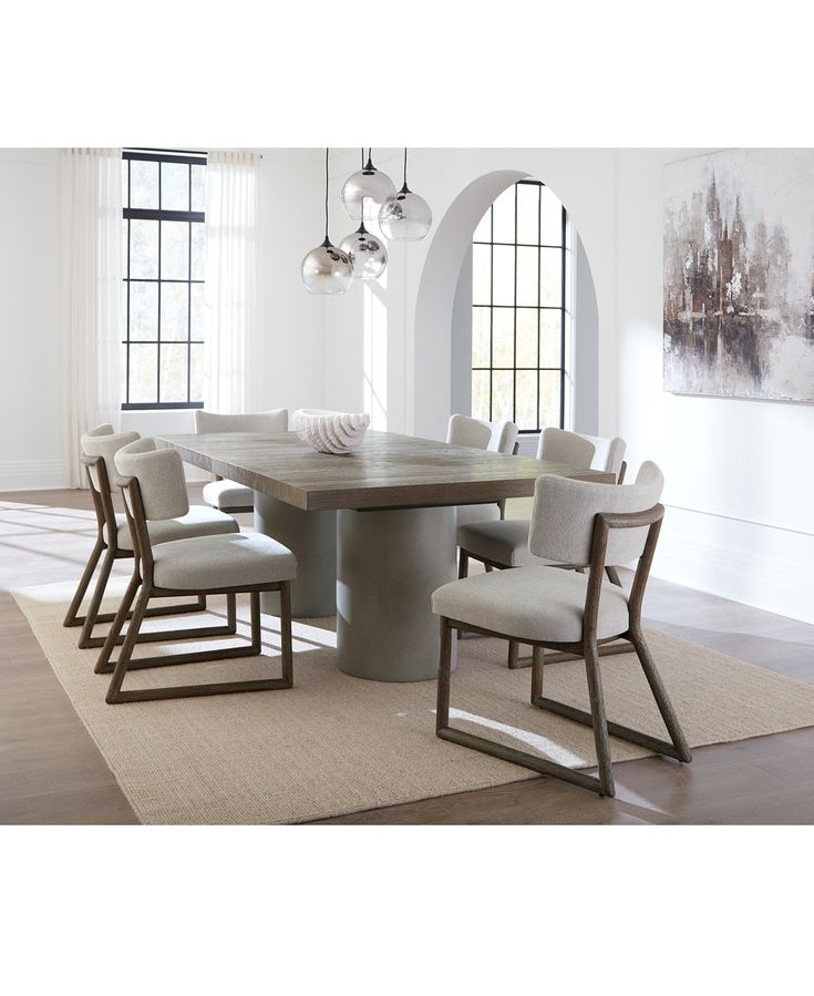 a dining table with six chairs and a rug on the floor in front of it