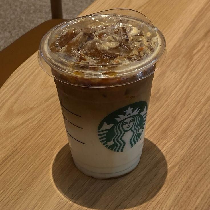 a starbucks drink sitting on top of a wooden table