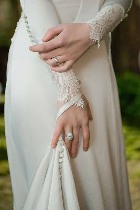 a woman in a white dress is holding her hand on the other side of her arm