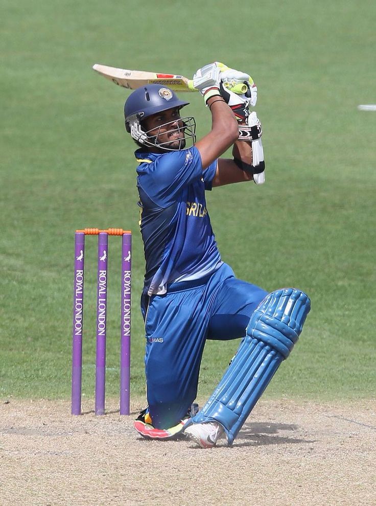 a man in blue uniform playing a game of cricket