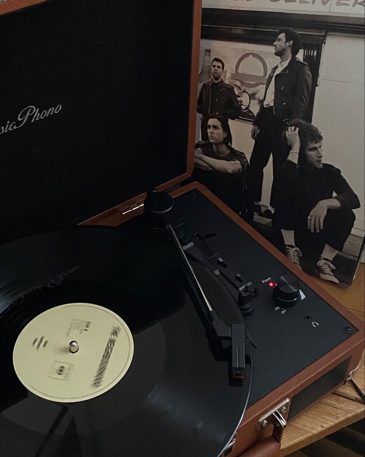 an old record player sitting on top of a wooden table next to a vinyl album