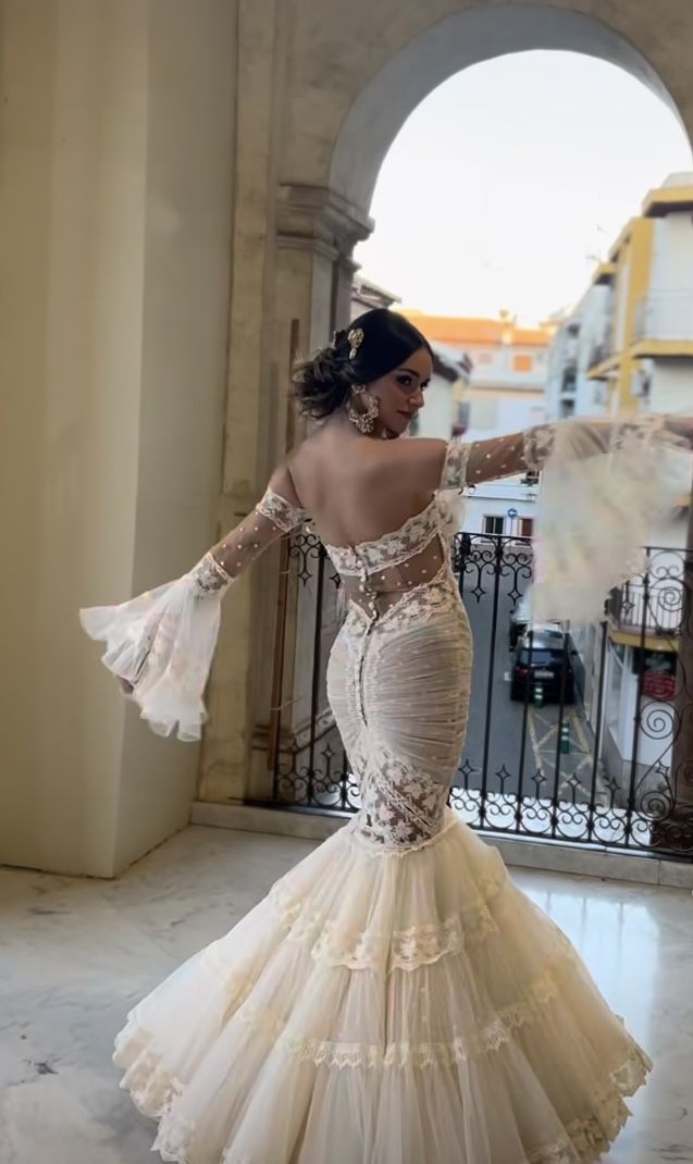 a woman in a wedding dress is posing for the camera with her arms outstretched and hands out