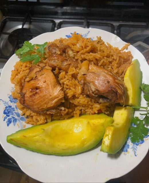 a white plate topped with rice and veggies next to an avocado