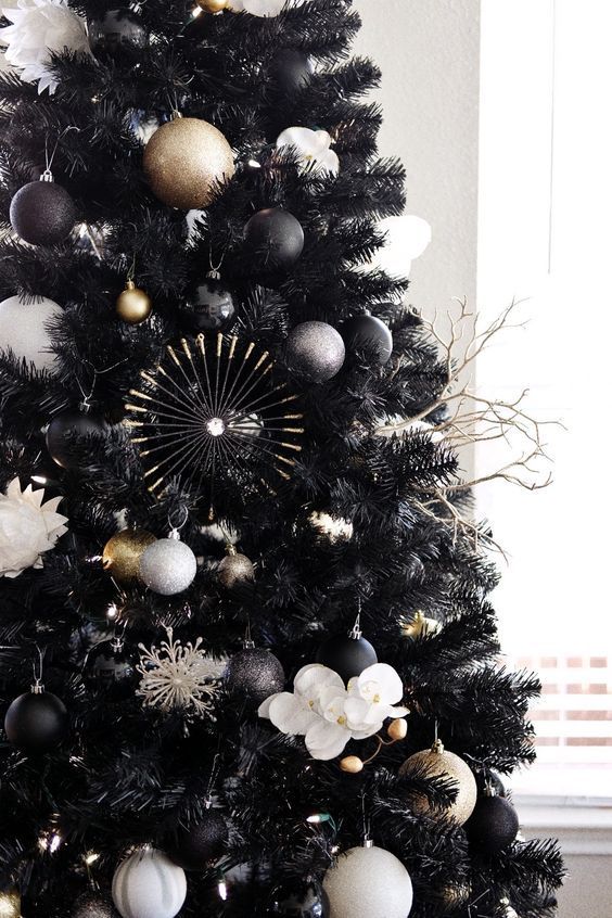 a black christmas tree with white and gold ornaments