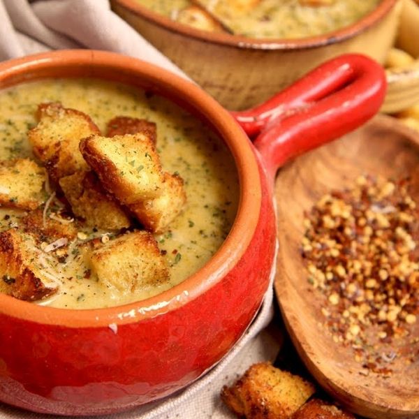 two red bowls filled with soup next to bread