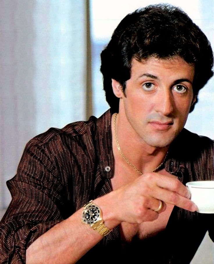 a black and white photo of a man holding a coffee cup