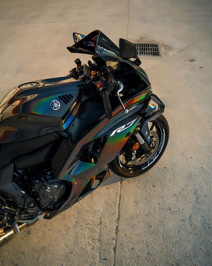 a black motorcycle parked on top of a cement road