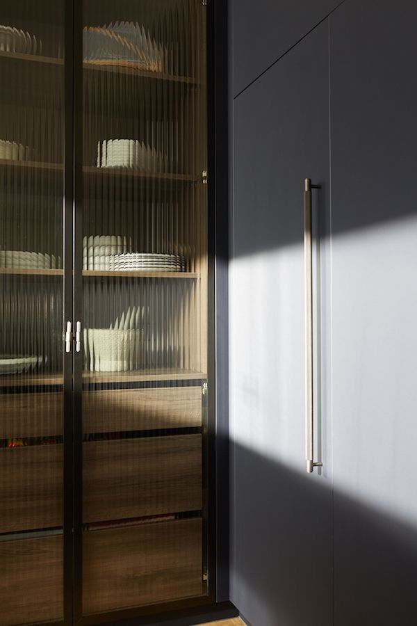 a cabinet with glass doors is shown in the sunlight, and there are dishes on it