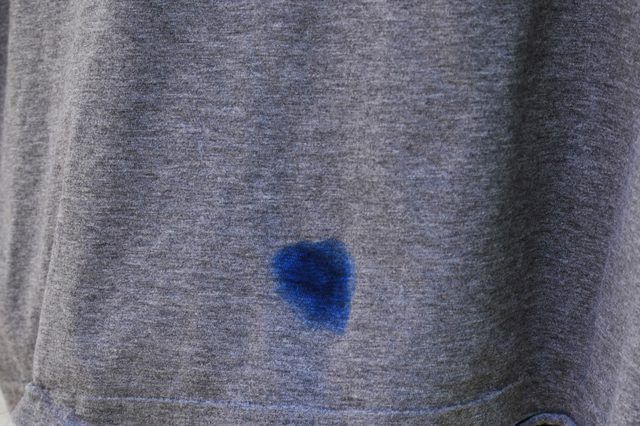 a person wearing a gray shirt with blue spots on it