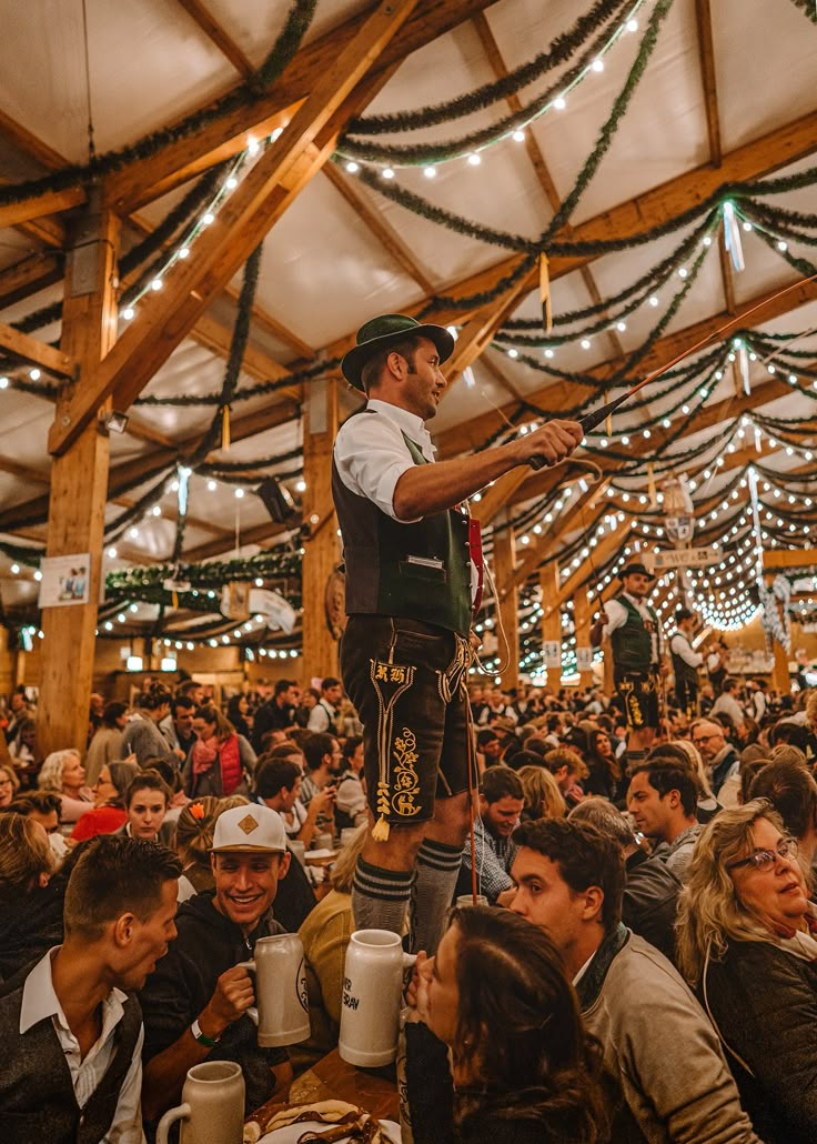 a man standing on top of a wooden structure surrounded by lots of people