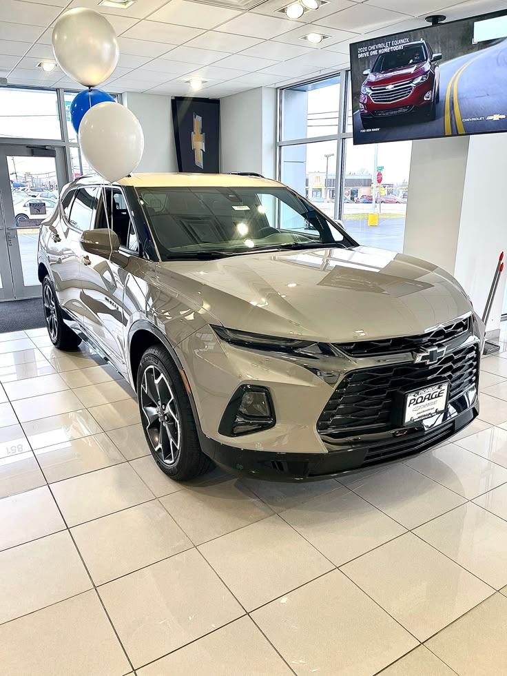 a white car in a showroom with balloons