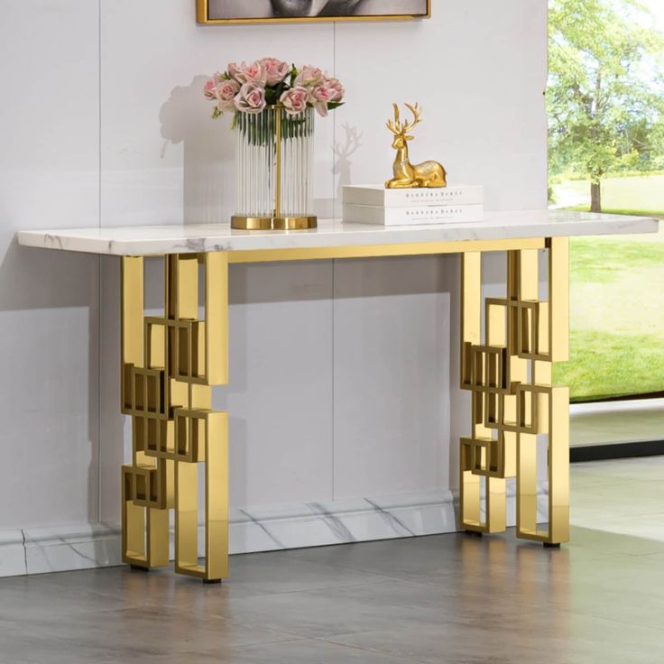 a white marble table with gold accents and flowers in vases on the top shelf