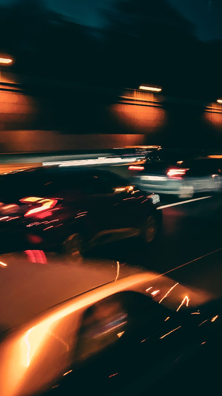 blurry photograph of cars driving down the road at night