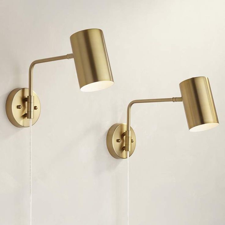 two gold wall lights on a white wall with one light turned off and the other turned off