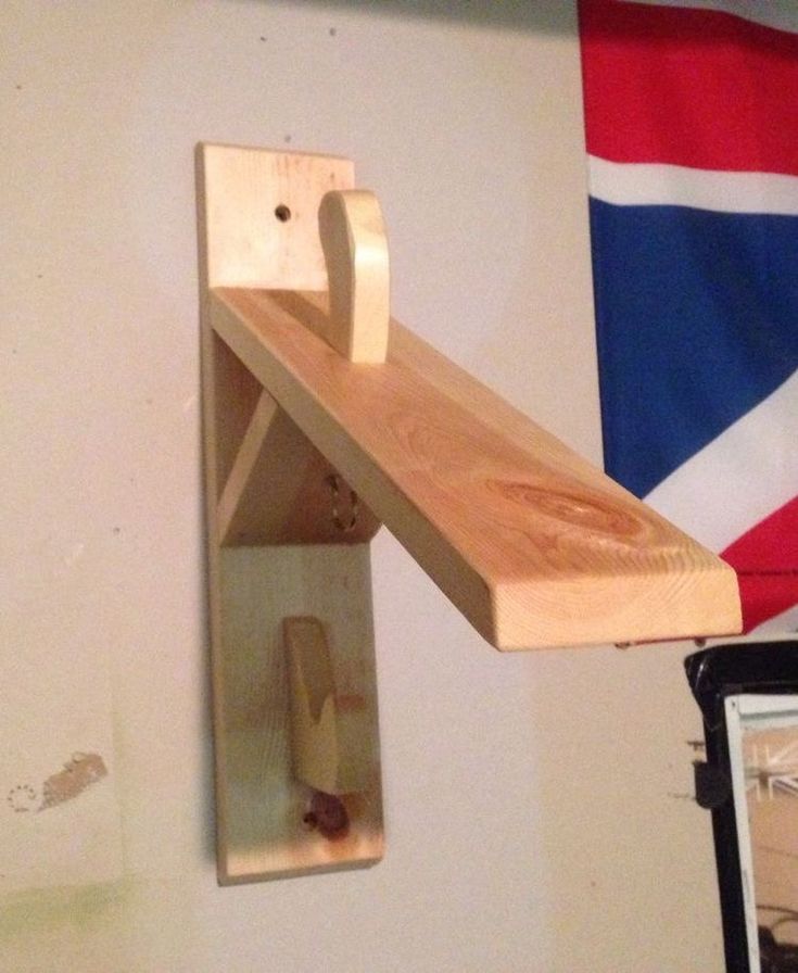 a wooden shelf mounted to the side of a wall with a flag in the background