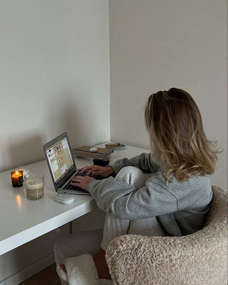 a woman sitting at a desk using a laptop computer