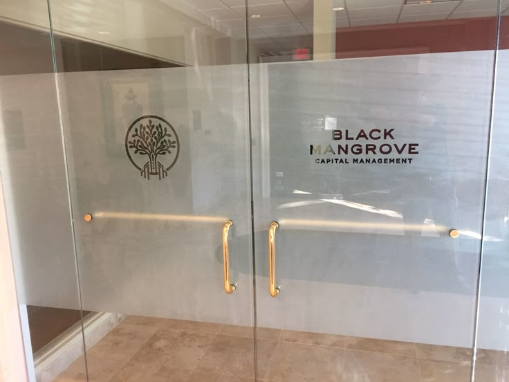 two glass doors with the words black mangrove capital management on them