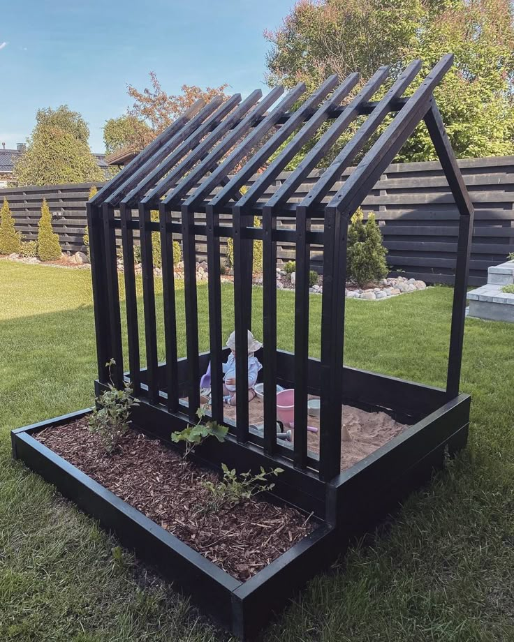 a house shaped planter in the middle of some grass