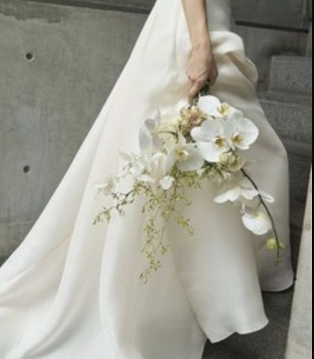 a woman in a white dress holding a bouquet of flowers