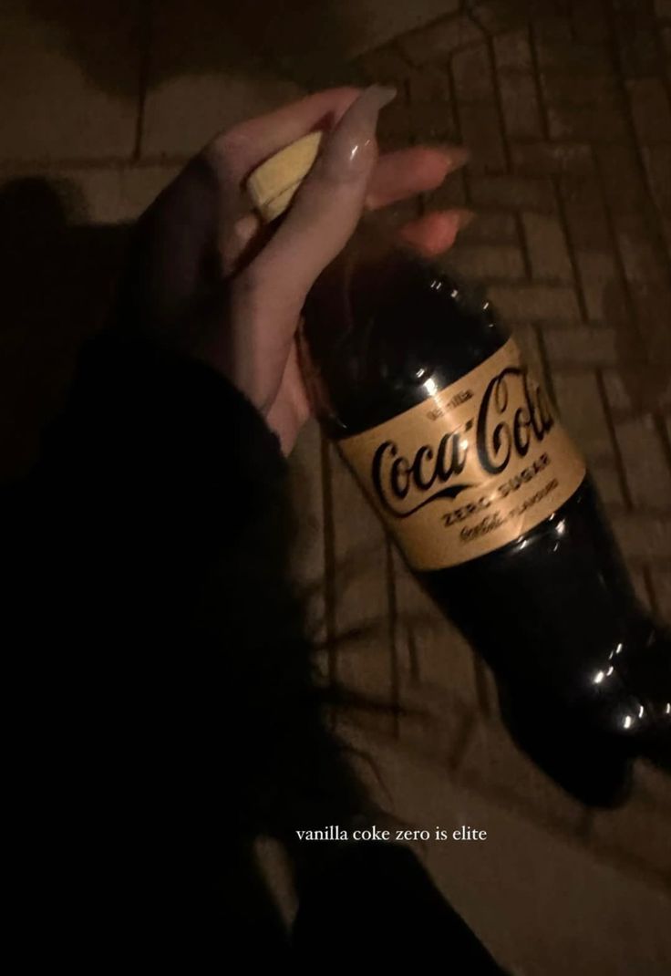 a person holding a bottle of coca cola